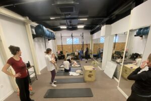 Clase grupal de recuperación postparto con madres y bebés